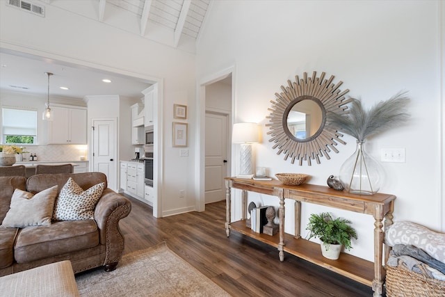 living area with dark wood-type flooring, baseboards, and recessed lighting