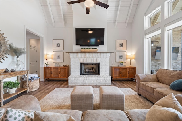 living area with beam ceiling, ceiling fan, wood finished floors, wooden ceiling, and high vaulted ceiling
