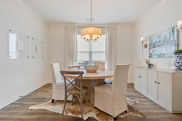 dining room with a chandelier, ornamental molding, wood finished floors, and baseboards
