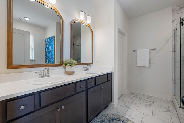 full bathroom with marble look tiles, double vanity, tiled shower, and baseboards