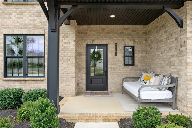 view of exterior entry featuring brick siding