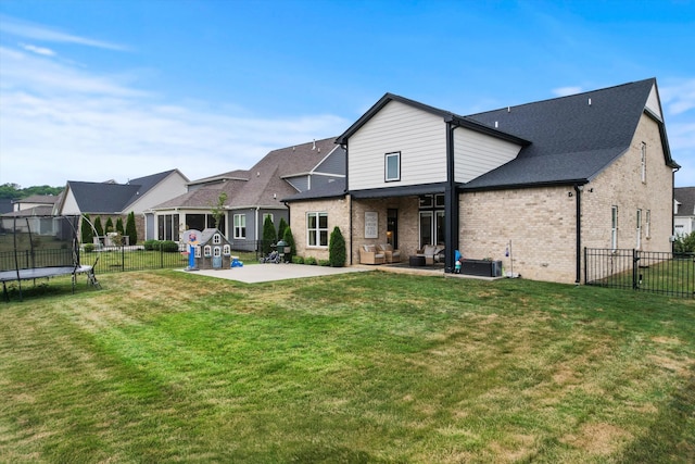 rear view of property featuring a patio area, a trampoline, brick siding, an outdoor living space, and central AC unit