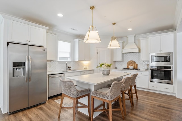kitchen featuring stainless steel appliances, custom range hood, a sink, tasteful backsplash, and crown molding