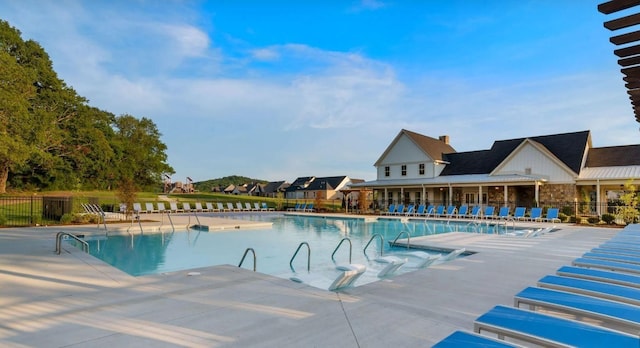 community pool with fence and a patio area