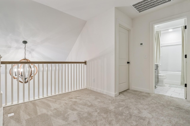 unfurnished room with a chandelier, carpet flooring, and baseboards