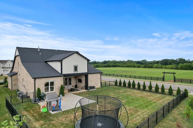 back of house featuring brick siding, a patio, and an outdoor fire pit