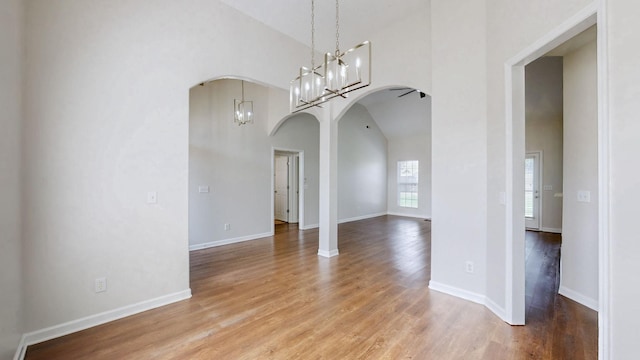 2014 Patrick Way, Spring Hill, TN 37174 - unfurnished room with arched walkways, wood finished floors, a chandelier, high vaulted ceiling, and baseboards