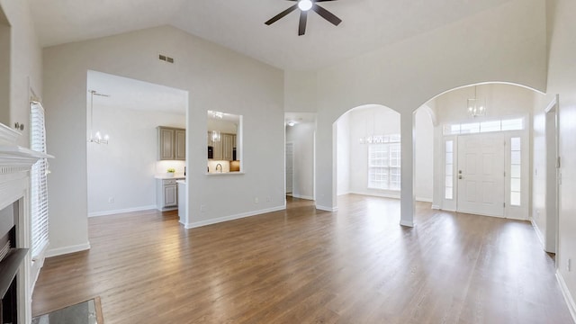 2014 Patrick Way, Spring Hill, TN 37174 - unfurnished living room with a ceiling fan, a chandelier, a fireplace, high vaulted ceiling, and arched walkways