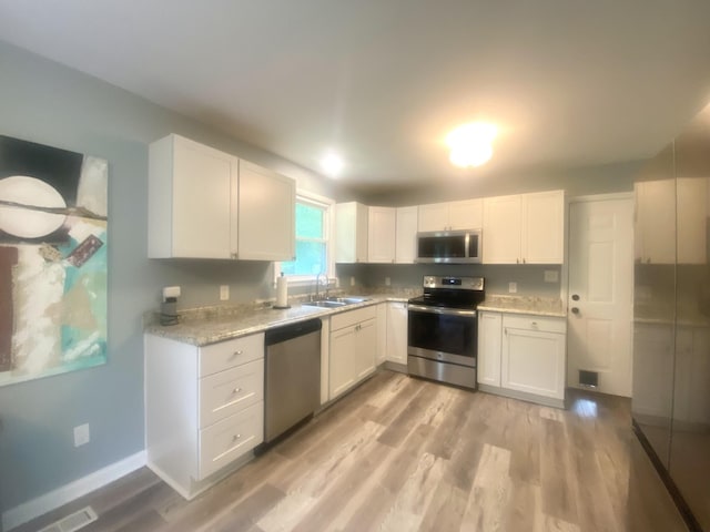 148 Shawna Ln, Hillsboro, TN 37342 - kitchen featuring stainless steel appliances, a sink, light wood-style floors, and white cabinets