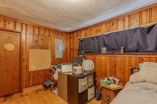 3913 Pickering Ave, Chattanooga, TN 37415 - bedroom featuring electric panel, light wood-style flooring, wooden walls, and a textured ceiling
