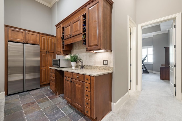 109 Allenhurst Cir, Franklin, TN 37067 - kitchen with appliances with stainless steel finishes, crown molding, brown cabinets, decorative backsplash, and light stone countertops