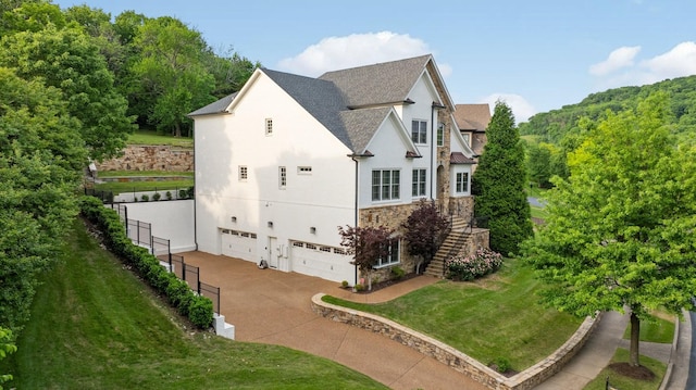 109 Allenhurst Cir, Franklin, TN 37067 - view of side of home featuring stone siding, stairs, an attached garage, driveway, and stucco siding