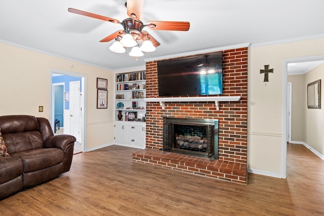 1403 Manor Rd, Columbia, TN 38401 - living area featuring wood finished floors, a ceiling fan, built in shelves, crown molding, and baseboards