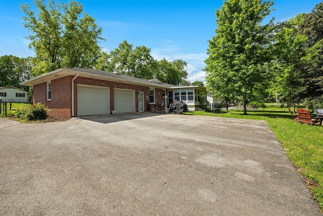 1403 Manor Rd, Columbia, TN 38401 - view of front of property featuring an attached garage, brick siding, a front yard, and asphalt driveway