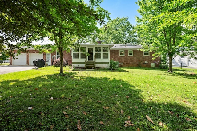 1403 Manor Rd, Columbia, TN 38401 - view of front of home featuring a sunroom, a front yard, concrete driveway, and a garage