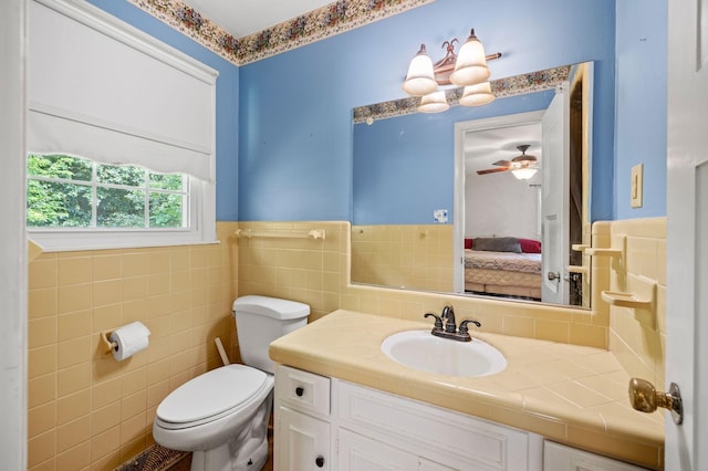 1403 Manor Rd, Columbia, TN 38401 - ensuite bathroom with toilet, vanity, tile walls, a wainscoted wall, and a ceiling fan