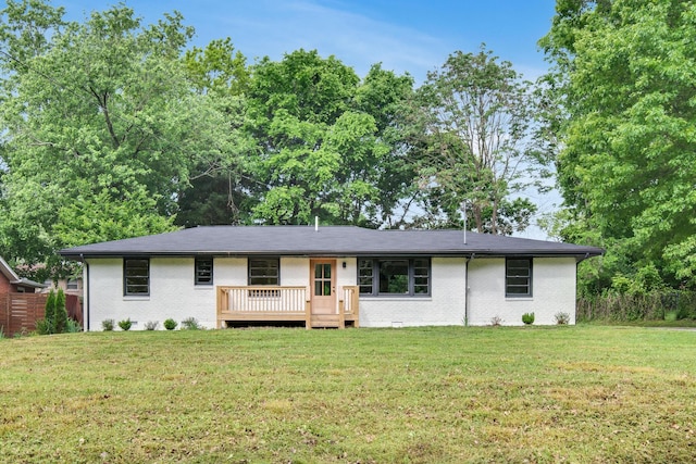 ranch-style house featuring a front lawn, a deck, and brick siding