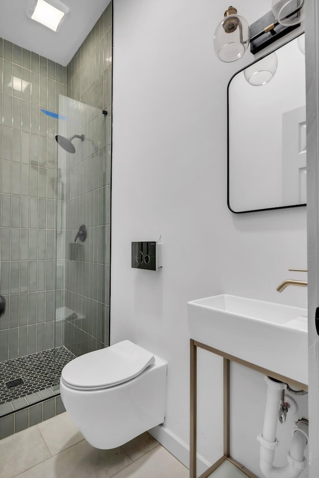 bathroom with tiled shower, tile patterned flooring, and toilet