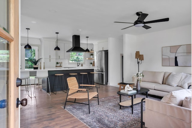 living area featuring ceiling fan and dark wood-style floors