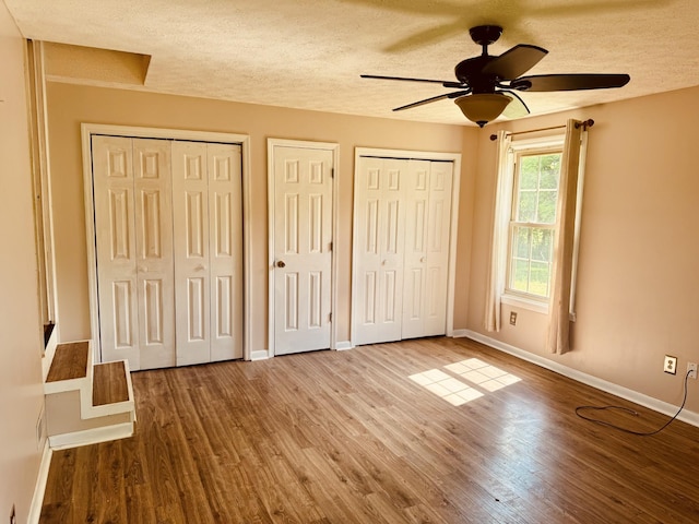 202 Tomlinson Rd, Lebanon, TN 37087 - unfurnished bedroom with a textured ceiling, wood finished floors, baseboards, multiple closets, and ceiling fan