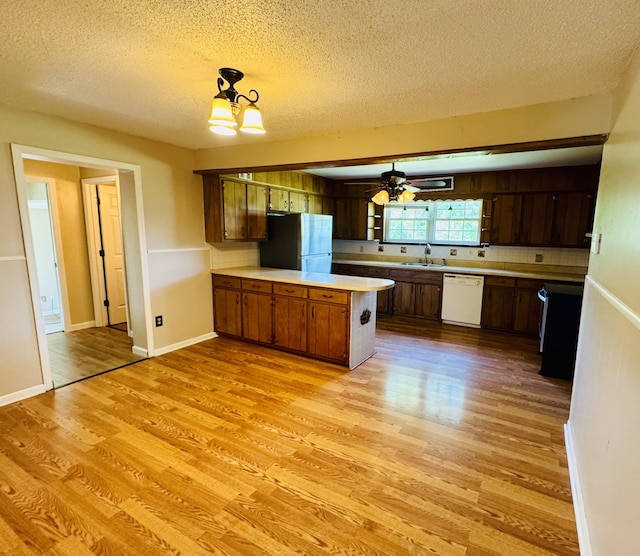 202 Tomlinson Rd, Lebanon, TN 37087 - kitchen featuring freestanding refrigerator, white dishwasher, light wood finished floors, a peninsula, and light countertops