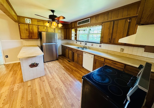 202 Tomlinson Rd, Lebanon, TN 37087 - kitchen with freestanding refrigerator, dishwasher, black / electric stove, brown cabinets, and light wood-style floors