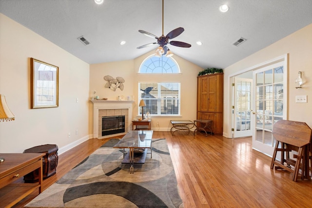 living room with light wood-style floors, vaulted ceiling, a fireplace, ceiling fan, and recessed lighting