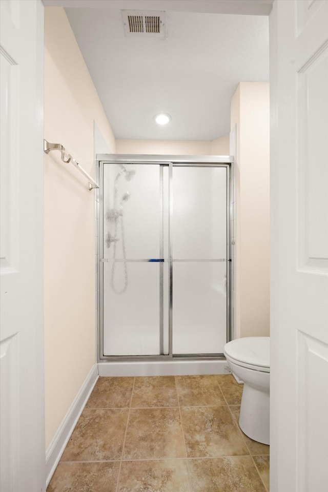bathroom with a shower stall, toilet, baseboards, and recessed lighting
