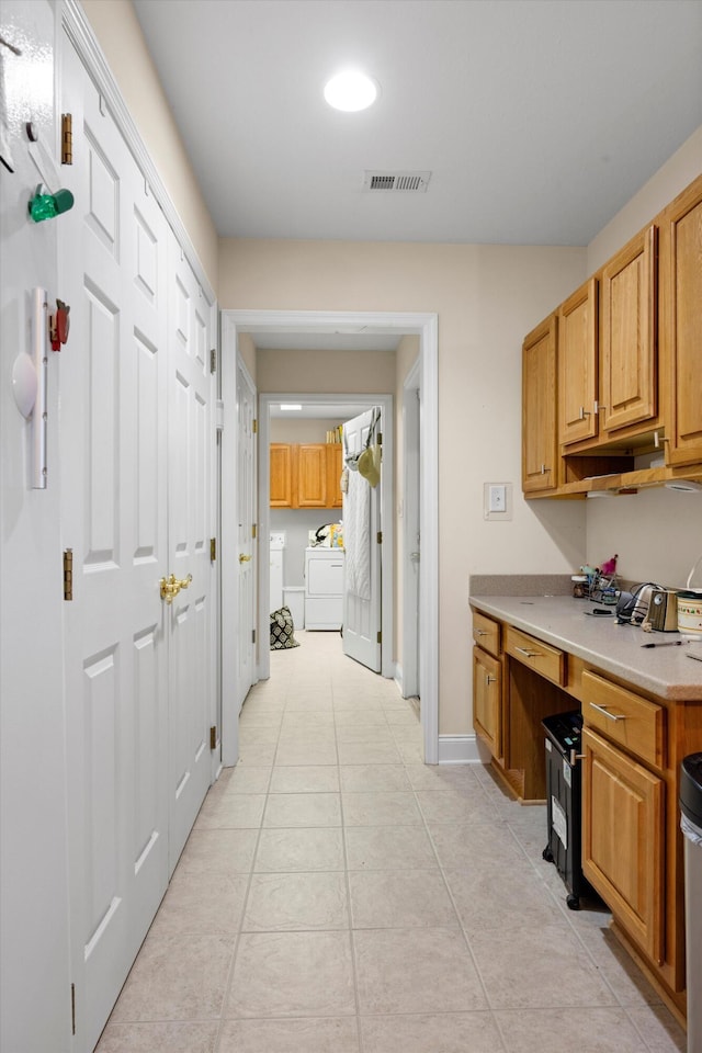 kitchen featuring light tile patterned floors, light countertops, and baseboards