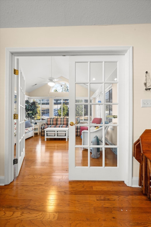 dining space featuring vaulted ceiling, hardwood / wood-style flooring, french doors, and a ceiling fan