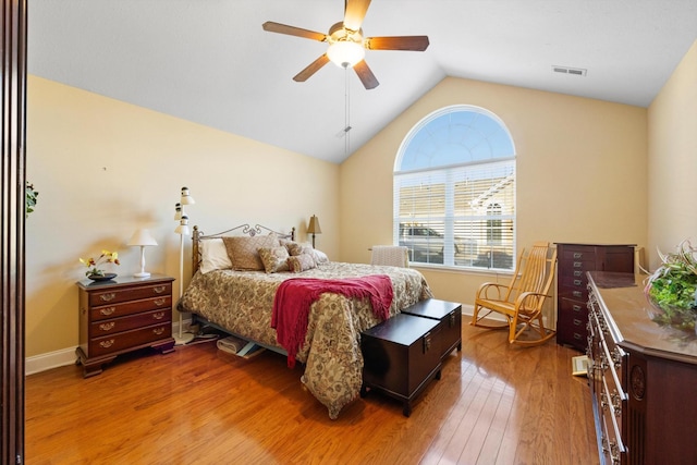 bedroom featuring wood finished floors, vaulted ceiling, a ceiling fan, and baseboards