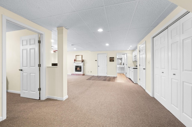 6716 Autumnwood Dr, Nashville, TN 37221 - basement with light colored carpet, a fireplace with raised hearth, recessed lighting, a drop ceiling, and baseboards