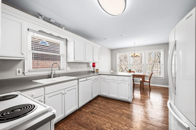 6716 Autumnwood Dr, Nashville, TN 37221 - kitchen featuring white appliances, a sink, a peninsula, a chandelier, and white cabinets