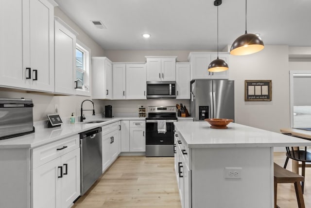 178 Charleston Ave, Pleasant View, TN 37146 - kitchen with appliances with stainless steel finishes, a sink, a kitchen breakfast bar, a center island, and light wood-type flooring