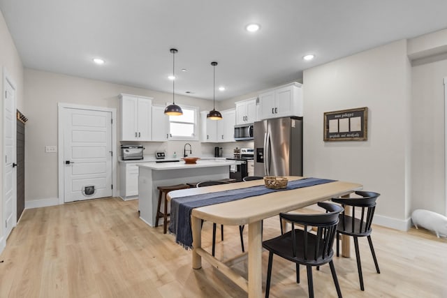 178 Charleston Ave, Pleasant View, TN 37146 - kitchen with stainless steel appliances, a center island, white cabinetry, light wood-type flooring, and recessed lighting