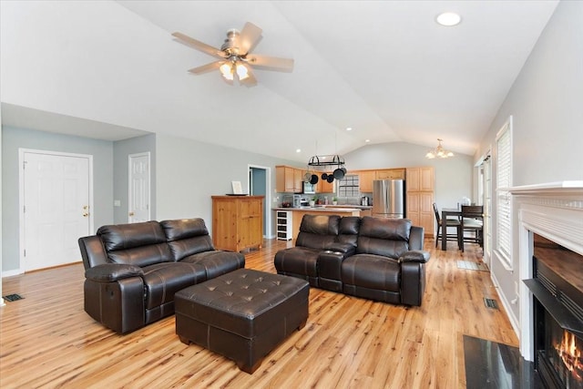 2129 Hollandale Cir, Columbia, TN 38401 - living area featuring a fireplace with flush hearth, lofted ceiling, light wood-style flooring, a chandelier, and ceiling fan