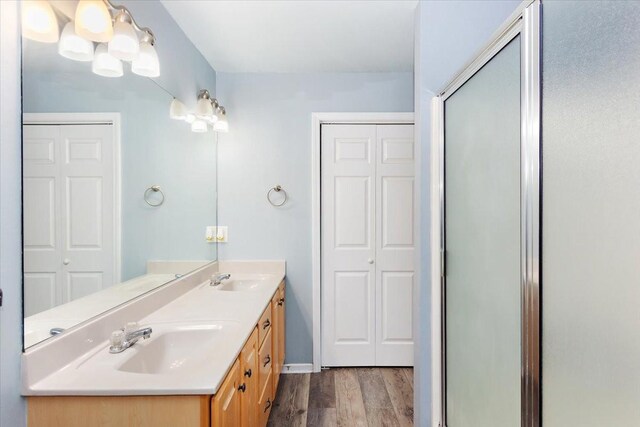 2129 Hollandale Cir, Columbia, TN 38401 - full bathroom featuring wood finished floors, double vanity, a stall shower, and baseboards