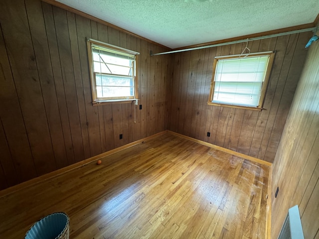 2168 Jefferson Rd, Smithville, TN 37166 - unfurnished room with hardwood / wood-style flooring, a textured ceiling, wood walls, and baseboards