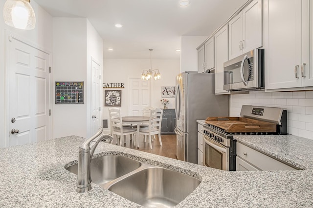 706 Hahn Ct, Lebanon, TN 37087 - kitchen with appliances with stainless steel finishes, a sink, a chandelier, decorative backsplash, and recessed lighting