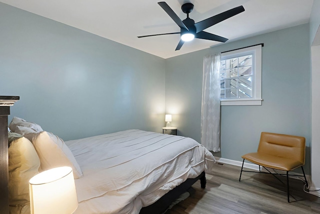 bedroom with wood finished floors, baseboards, and a ceiling fan