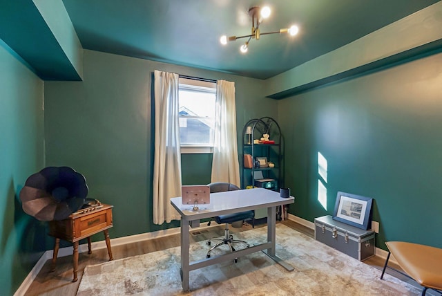 home office featuring a chandelier, wood finished floors, and baseboards