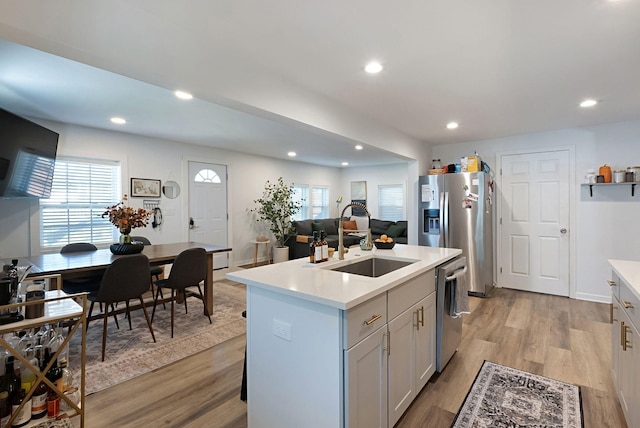 kitchen with a sink, stainless steel appliances, light countertops, plenty of natural light, and recessed lighting