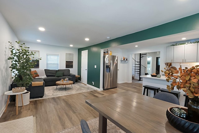 living area with stairway, wood finished floors, baseboards, and recessed lighting