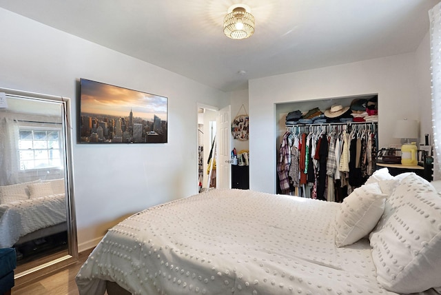 bedroom featuring a closet, wood finished floors, and baseboards