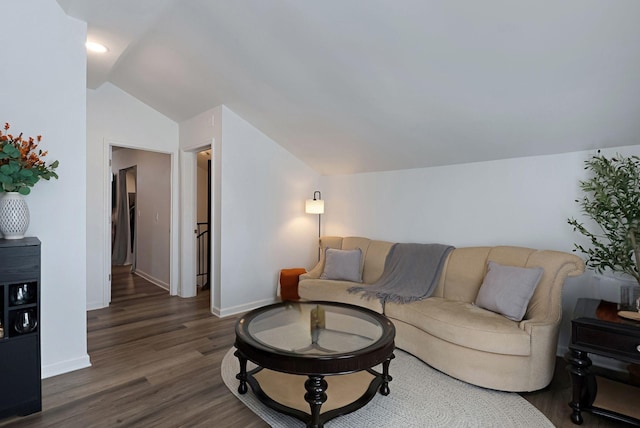 living area featuring lofted ceiling, dark wood-style flooring, and baseboards