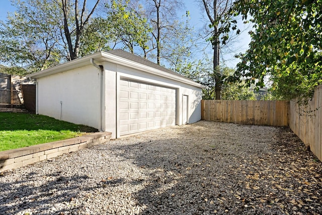 detached garage with fence and driveway