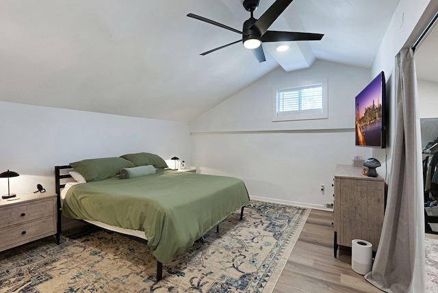 bedroom featuring lofted ceiling, wood finished floors, a ceiling fan, and baseboards