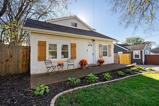 view of front facade with brick siding and roof with shingles