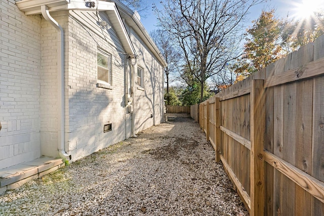 view of home's exterior featuring a fenced backyard, brick siding, and crawl space