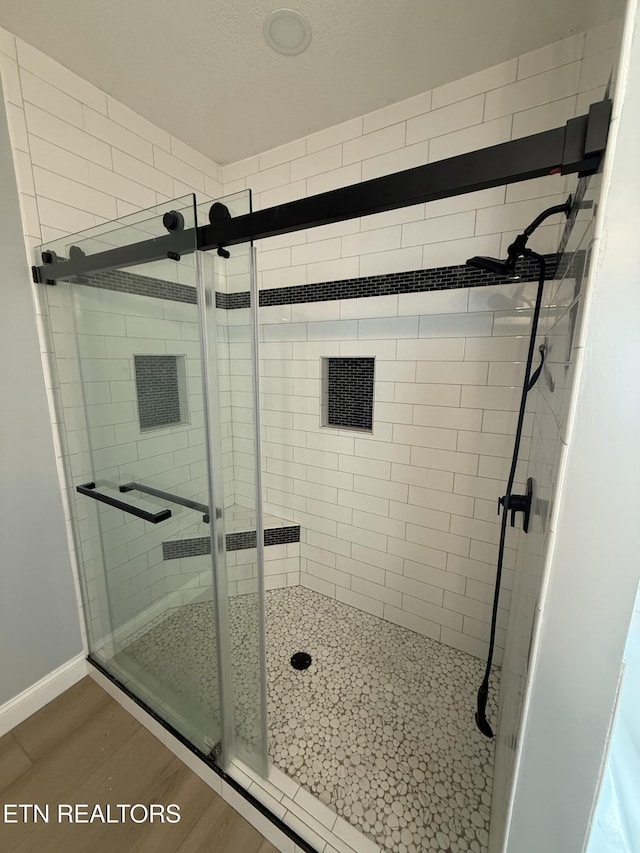 222 Ten Mile Ln, Ten Mile, TN 37880 - bathroom with a stall shower, wood finished floors, and baseboards